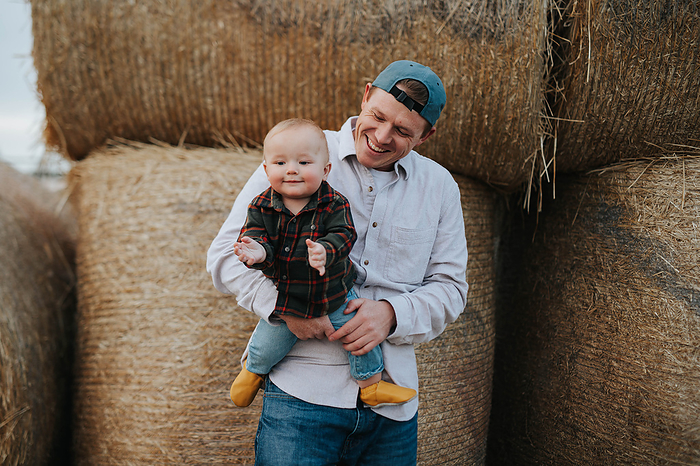 Dad and son hanging out at the pumpkin patch, by Cavan Images / Mandi Swandal Photography