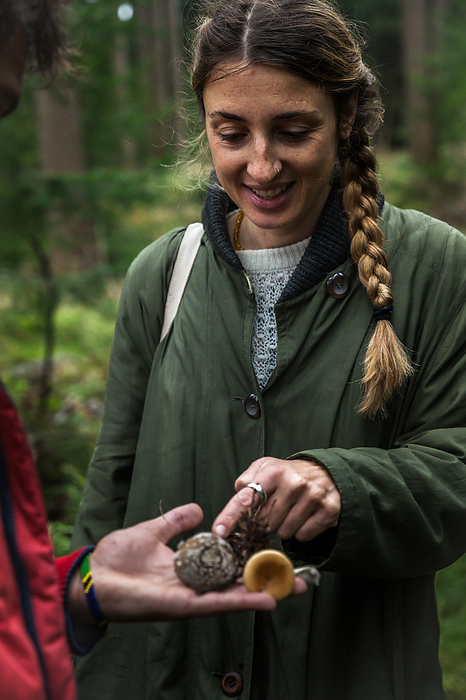 Woman Looking At Wild Mushrooms In A Forest In Scandinavia, by Cavan Images / Emily Wilson Photography