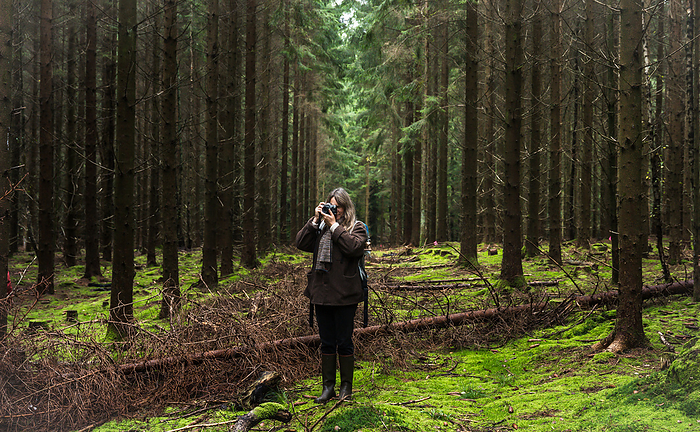Woman With Camera Taking Photos In The Forest in Denmark, by Cavan Images / Emily Wilson Photography