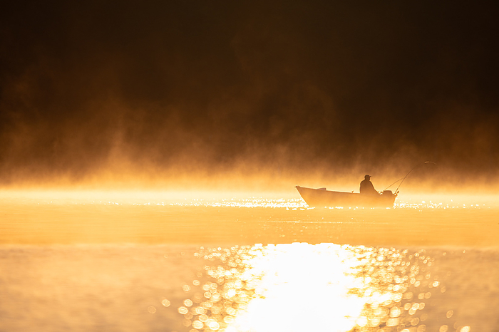A fisherman trolling at sunrise, by Cavan Images / Brett Protasiewicz