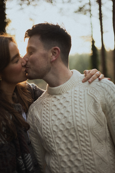 Young couple in love shares a kiss while taking a selfie, by Cavan Images / Sarah McKernan