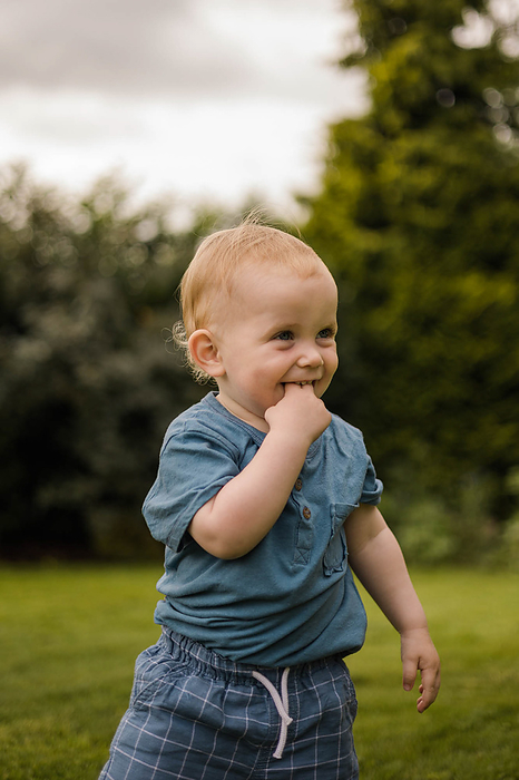 Sarah McKernan Stock Portfolio Cute toddler smiles and plays joyfully in the garden, by Cavan Images   Sarah McKernan