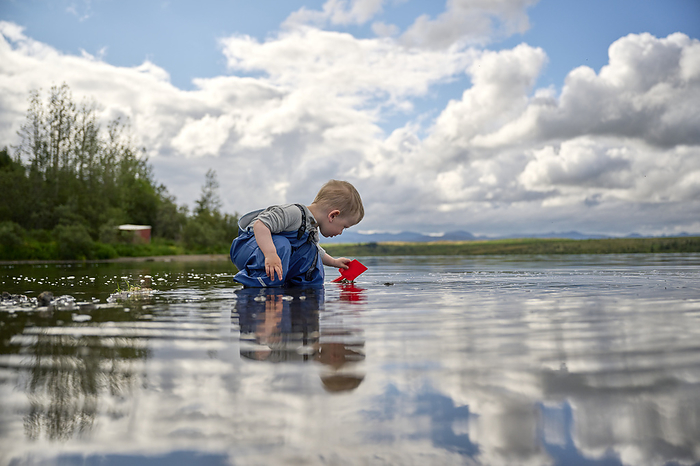 Toddler playing in tranquil lake, by Cavan Images / Oscar Bjarnason