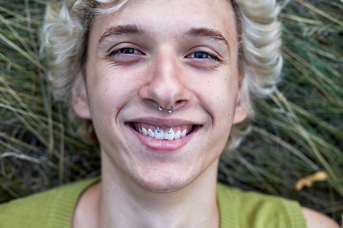 face of  laughing teenager with piercings, by Cavan Images / Elena Perevalova