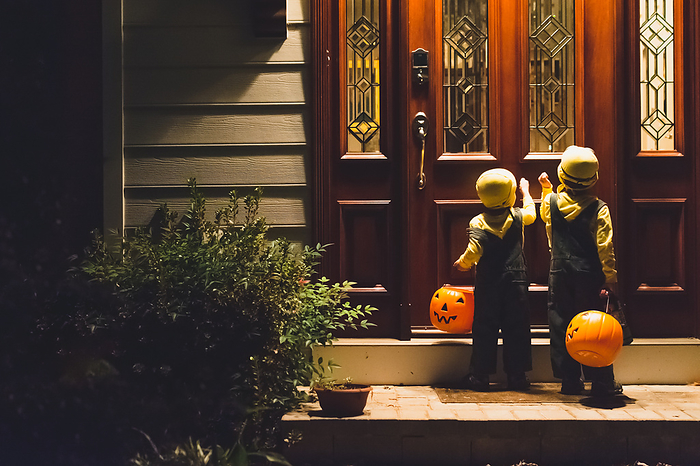 Young boys knocking on front door to trick or treat on Halloween. Young boys knocking on front door to trick or treat on Halloween., by Cavan Images   Sara Taylor