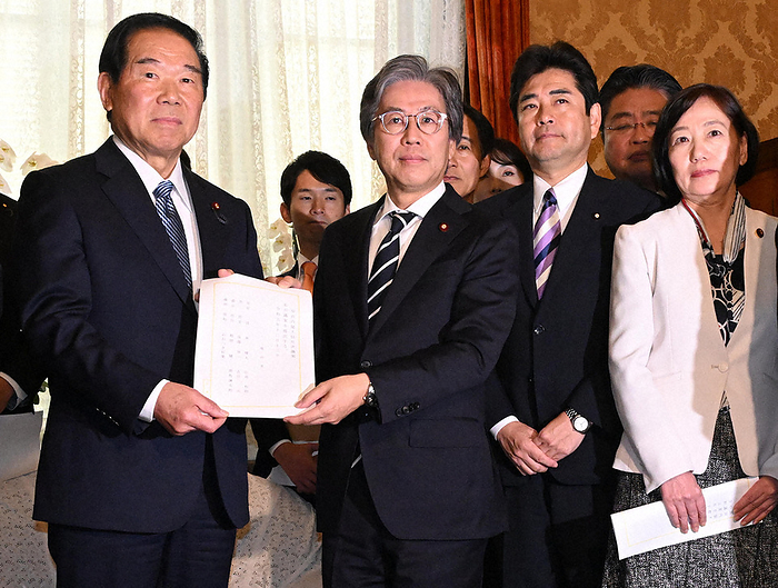 Jun Azumi, chairman of the National Diet Committee of the Democratic Party of Japan, and others presenting a no confidence motion in the Cabinet. Jun Azumi  second from left , chairman of the National Diet Committee of the Democratic Party of Japan  DPJ , and others submit a no confidence motion in the Cabinet to Nukaga Fukushiro  left , Speaker of the House of Representatives, at 0:46 p.m. on December 13, 2023, in the Diet.