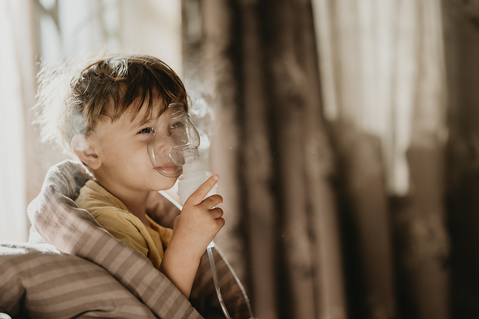 Preschool boy with nebulizer at home