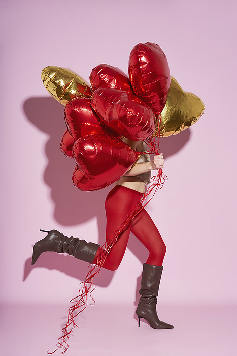 A woman in red tights runs with balls in her hands Women wearing stocking and running with heart shaped balloons