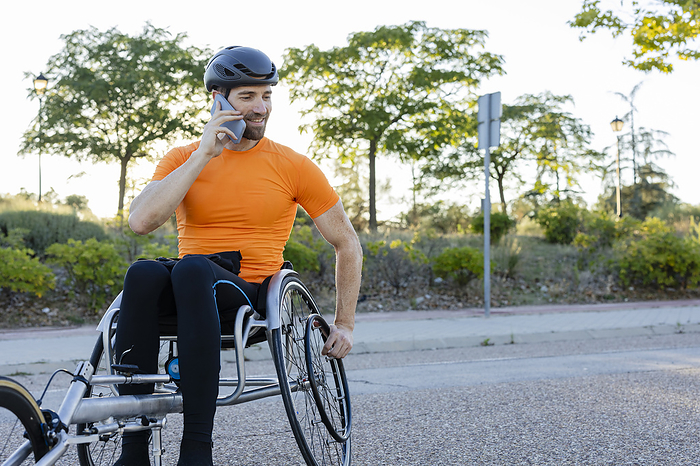 Sportsman talking on smart phone sitting in wheelchair