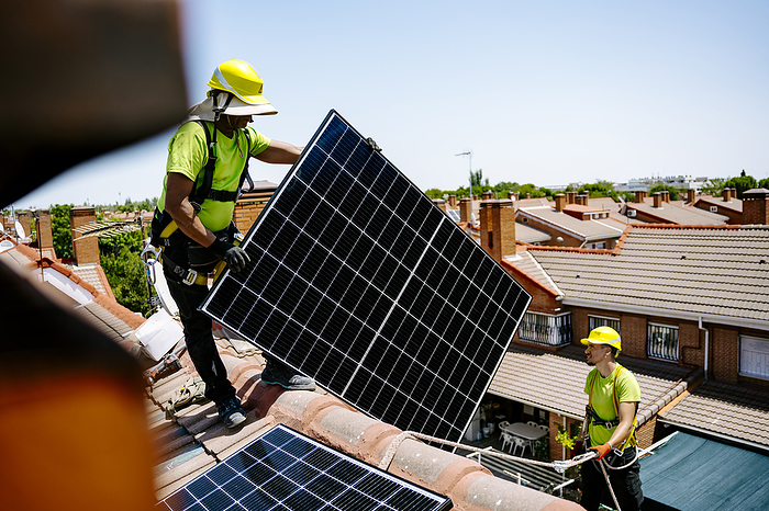 Solar power engineer installing solar panels in residential area Engineers installing solar panel on house roof