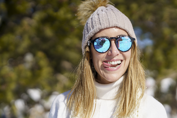 Smiling woman with tongue out in winter