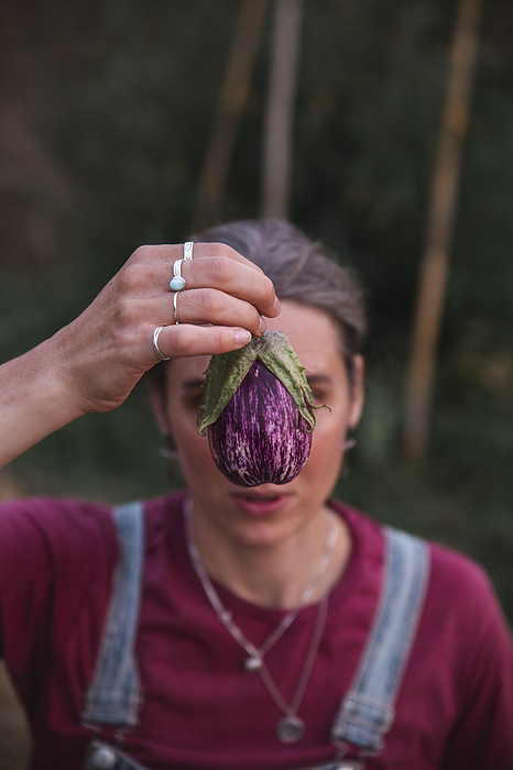 Woman holding eggplant over face