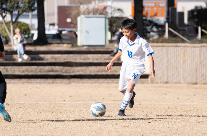 An elementary school boy playing a soccer game