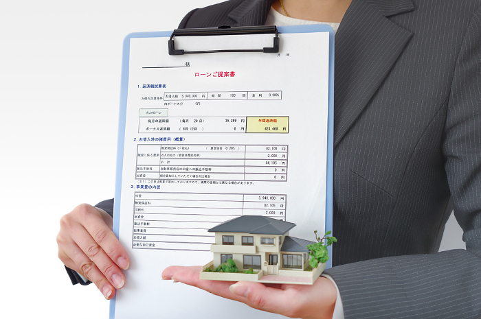 Woman with mortgage documents and house model