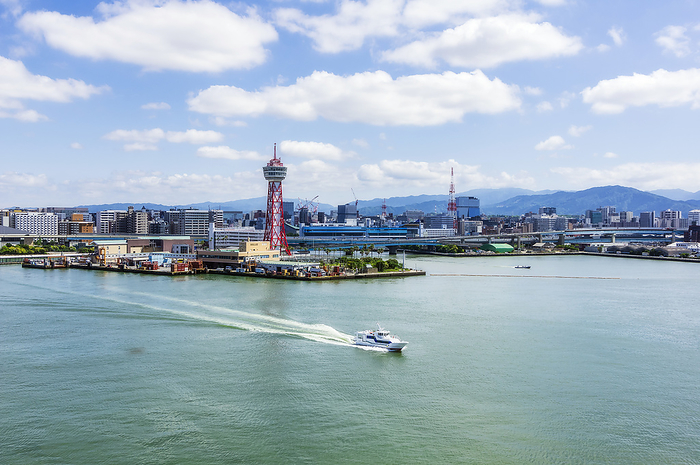 Japan, Fukuoka Prefecture, Fukuoka City, City harbor with motorboat sailing in foreground