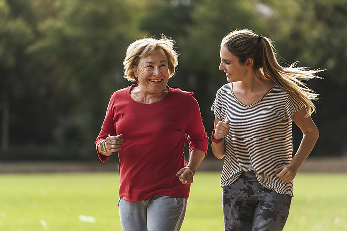 Granddaughter and grandmother having fun, jogging together in the park