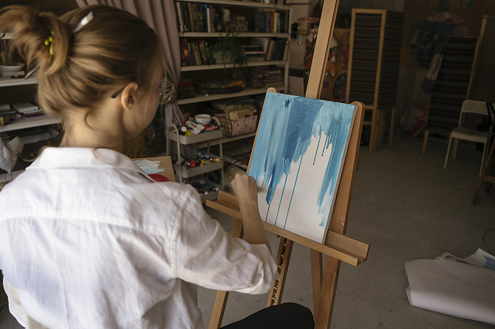 Artist painting on canvas at art studio