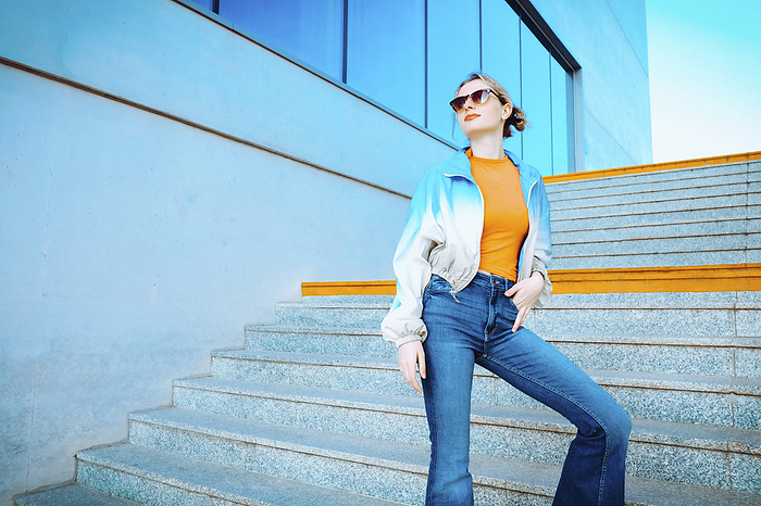Woman wearing sunglasses standing on staircase near building