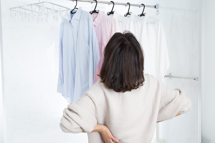 Woman drying laundry in bathroom
