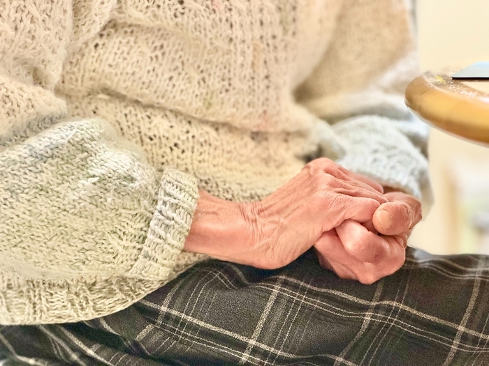 Elderly woman's hand holding both hands up and down