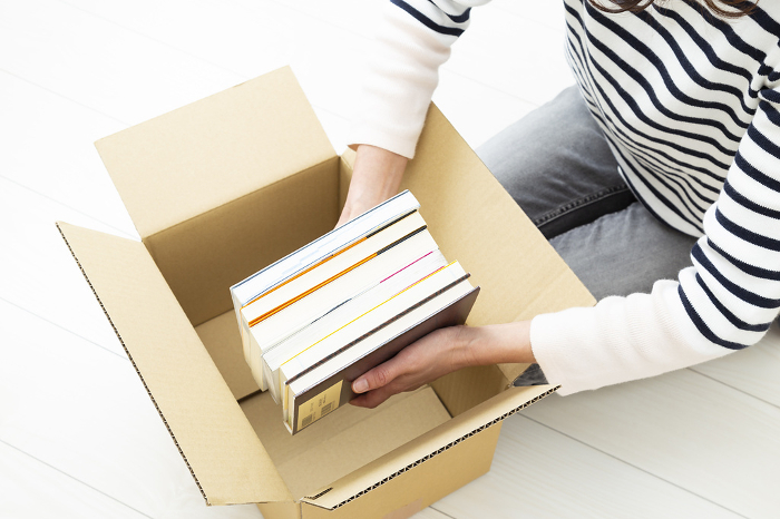 Woman packing books in cardboard boxes
