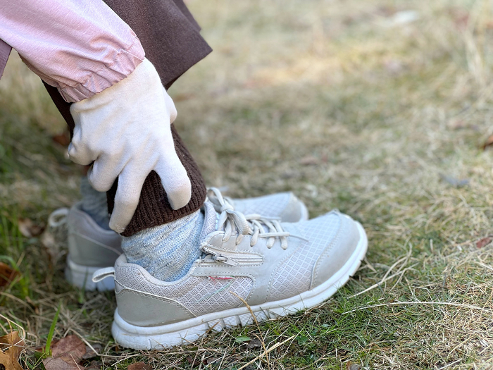 Elderly woman holding her ankle