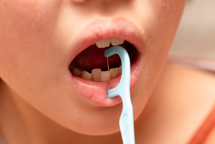 Children's mouths using dental floss