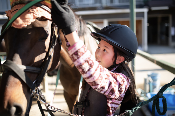 A child preparing for a horseback ride