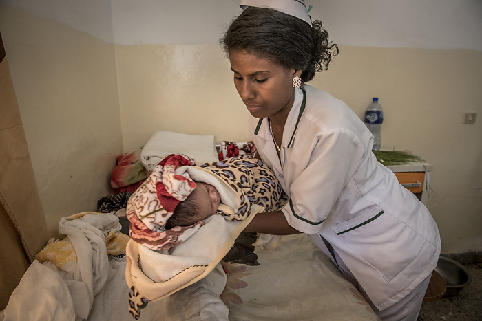 Newborn baby Nurse caring for a newborn at Lemlem Karl Hospital in Maichew, in the Tigray region of Ethiopia., by KAREN KASMAUSKI SCIENCE PHOTO LIBRARY