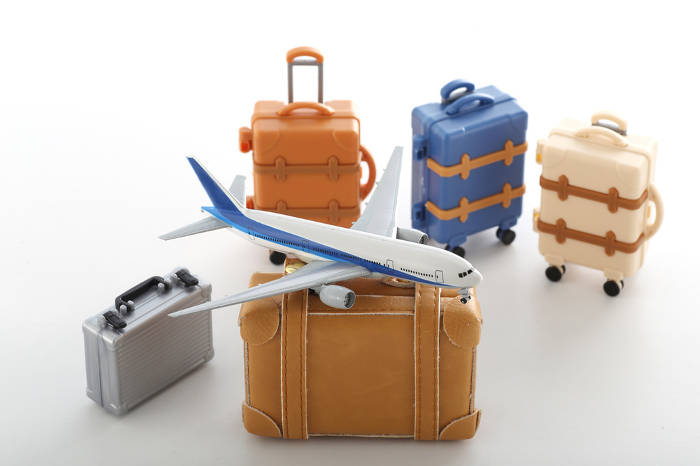 Image of a suitcase and a model airplane on a trip