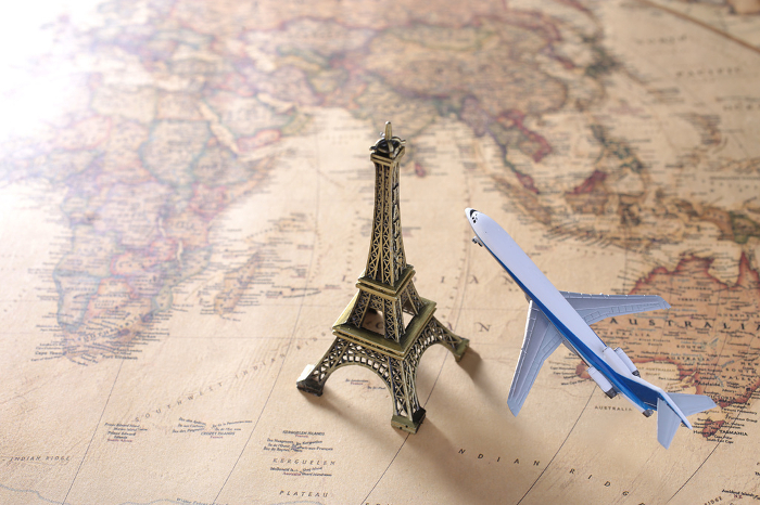 Image of international travel with world map, airplane, and model of the Eiffel Tower