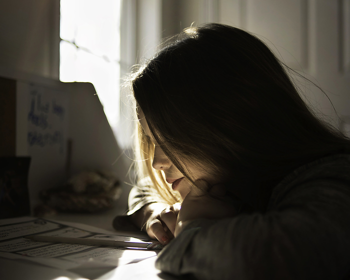 Young girl thinking about homework at desk, by Cavan Images / Joy Faith