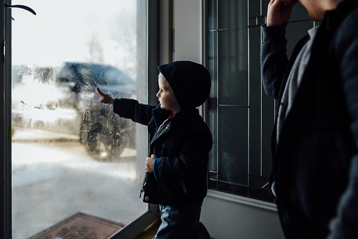 Side view of little boy wearing winter gear standing at frosty w, by Cavan Images / Kimberli Fredericks