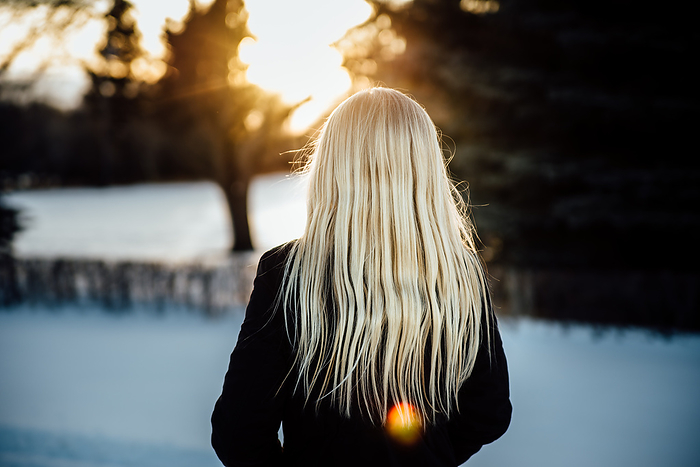 Close up of rear view of teen girl with long blond hair standing, by Cavan Images / Kimberli Fredericks