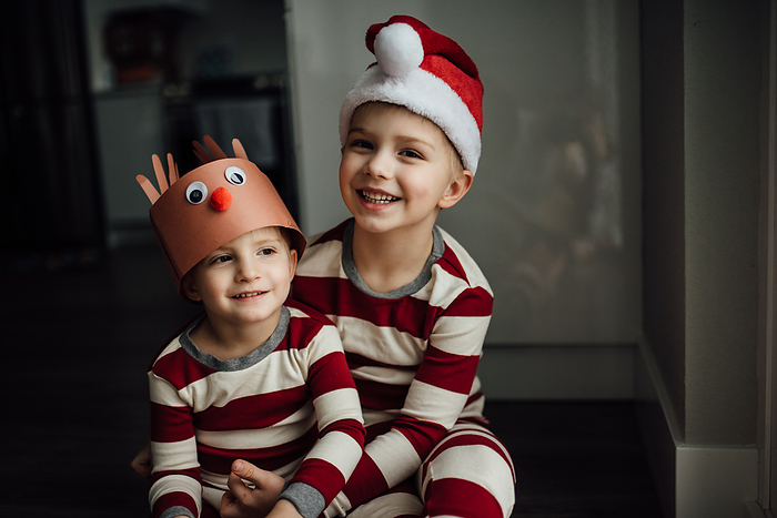 Close up of two little boy's smiling and wearing Christmas pajam, by Cavan Images / Kimberli Fredericks
