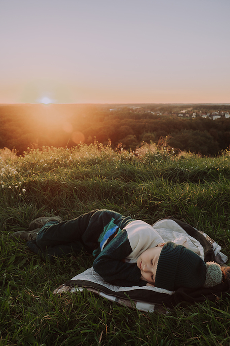 A cute boy having fun at the sunset, by Cavan Images / Darya Kisialiova