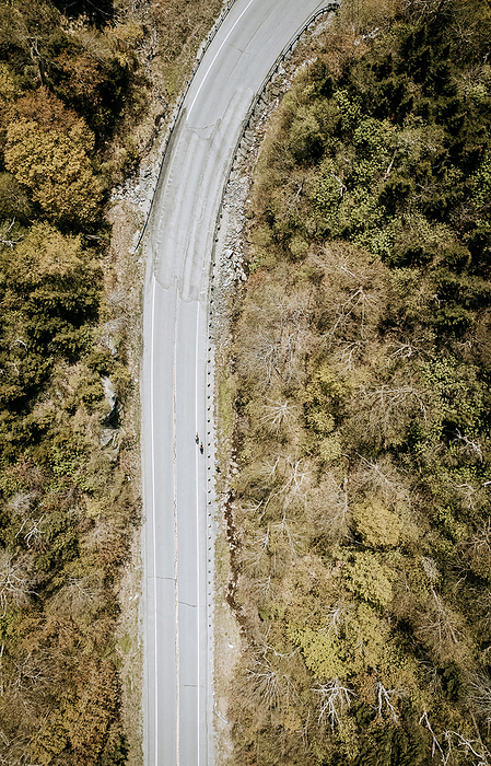 Aerial view of two cyclists riding up a mountain pass in Vermont, by Cavan Images / Chris Bennett