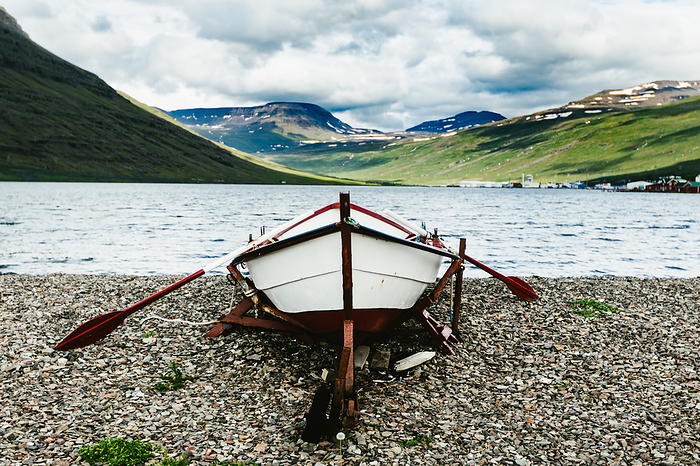 Old fishing boat on Icelandic eastern fjord rocky beach, by Cavan Images / Anna Rasmussen Photographs