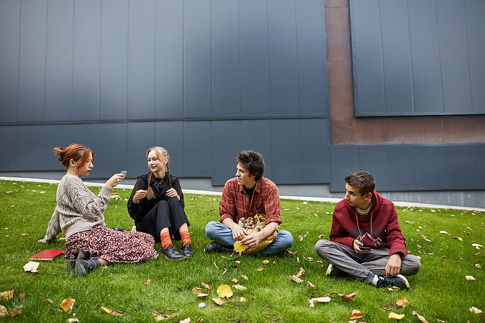 students spending leisure time on university campus, by Cavan Images / Elena Perevalova