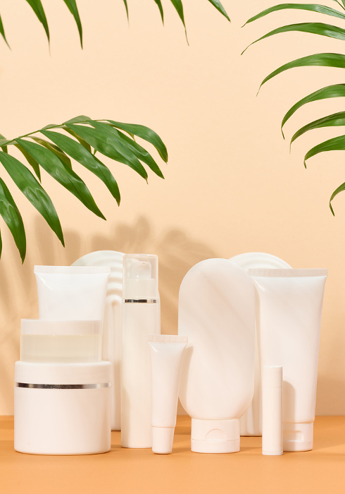 White plastic tubes, jars on a beige background, containers for cosmetic creams and gels, advertising and brand promotion White plastic tubes, jars on a beige background, containers for cosmetic creams and gels, advertising and brand promotion