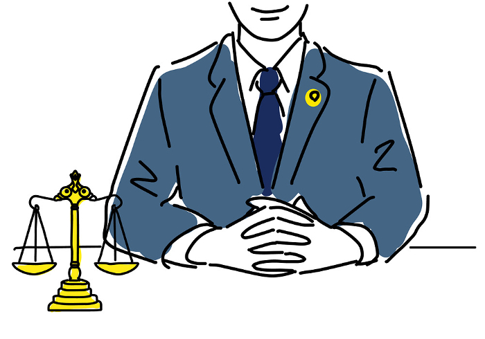 Simple line drawing of a male lawyer with hands folded in front of the scales of justice