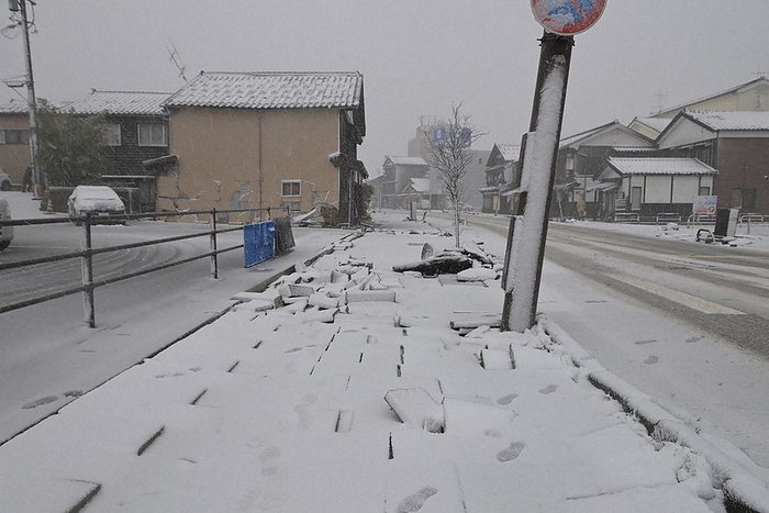 Major Earthquake of Magnitude 7 in Noto District, Wajima City, Ishikawa Prefecture A sidewalk with snow piled up in a crack in the ground. The town is almost deserted due to the snowfall.