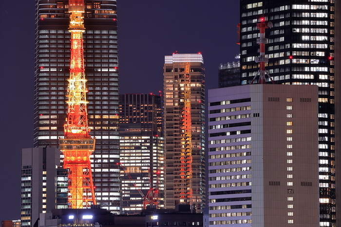 Night view of Tokyo Tower and surrounding skyscrapers in front of Aso dai Hills, Tokyo Taken from Toyosu Gururi Park. Tokyo Tower is reflected in the building on the right.