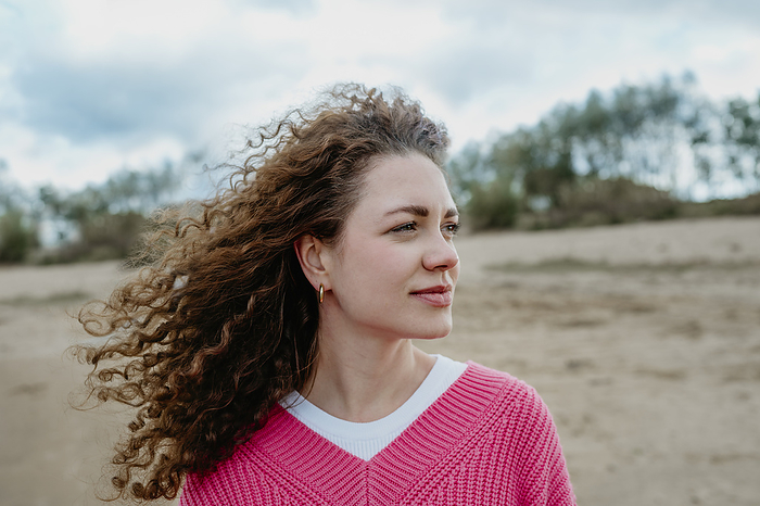 Happy woman with curly hair at beach