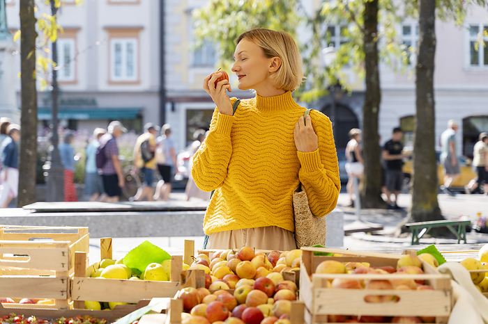 Woman smelling fresh apples at farmer's market