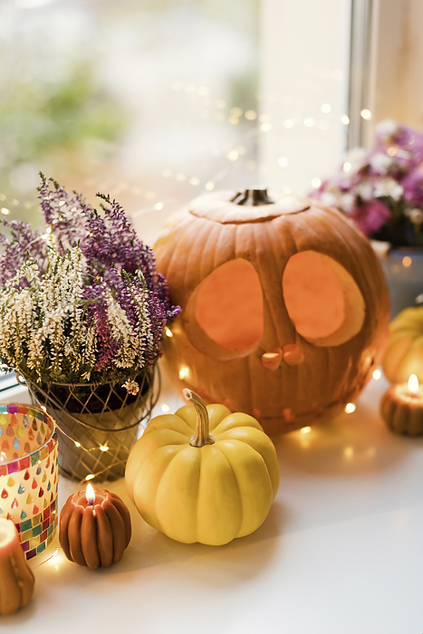 Halloween decorations with lights and carved pumpkins on window sill