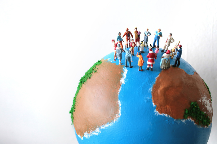 Globe and miniature dolls with the image of the earth with people from all over the world.