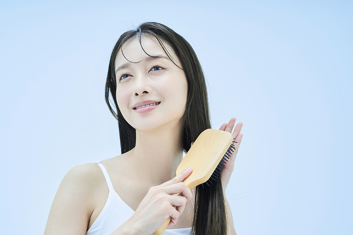 Japanese woman with long hair brushing her hair.
