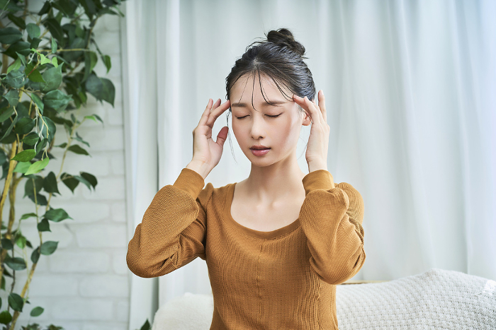 Young Japanese woman suffering from headache (People)