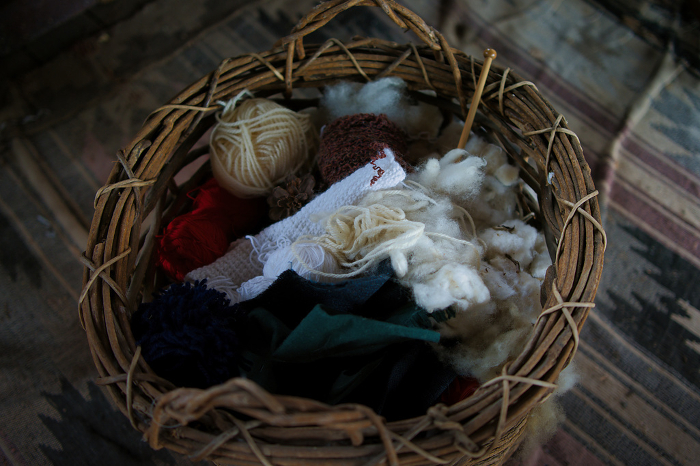 Hand-knitted balls of yarn and cotton in a basket